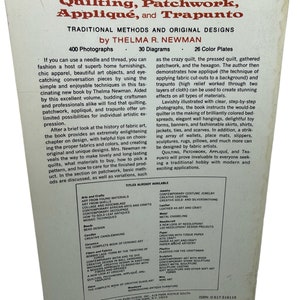 May include: Book cover with a brown background and white text. The title is "Quilting, Patchwork, Appliqu&eacute;, and Trapunto: Traditional Methods and Original Designs" by Thelma R. Newman. The book features 400 photographs, 30 diagrams, and 26 color plates.