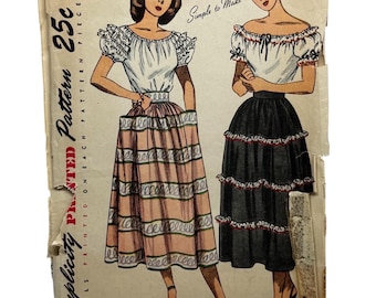 May include: Vintage Simplicity sewing pattern for a skirt and blouse. The pattern is printed on a white paper with a black and white illustration of two women wearing the garments. The pattern is labeled "Simplicity Printed Pattern 25c" and "Simple to Make".