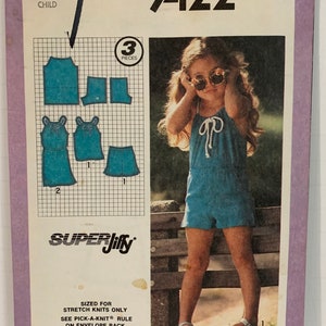 May include: Simplicity sewing pattern number 9422 for a child's sleeveless jumpsuit with a tie at the neck. The pattern is for stretch knits only and includes the Pick-A-Knit rule. The pattern is sized for a child size 5.