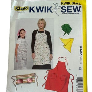 May include: A Kwik Sew sewing pattern packet, K3480, featuring apron designs. The packet includes images of aprons in various styles, a red apron with pockets, and a striped apron. The packet also shows two women wearing aprons.