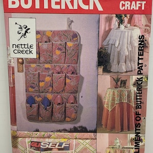 May include: A sewing pattern from Butterick, pattern number 4371, for a craft project. The pattern includes instructions for making a hanging shoe organizer, a table skirt, and a table runner. The shoe organizer is made of fabric with a floral print. The table skirt and table runner are made of fabric with a plaid print.