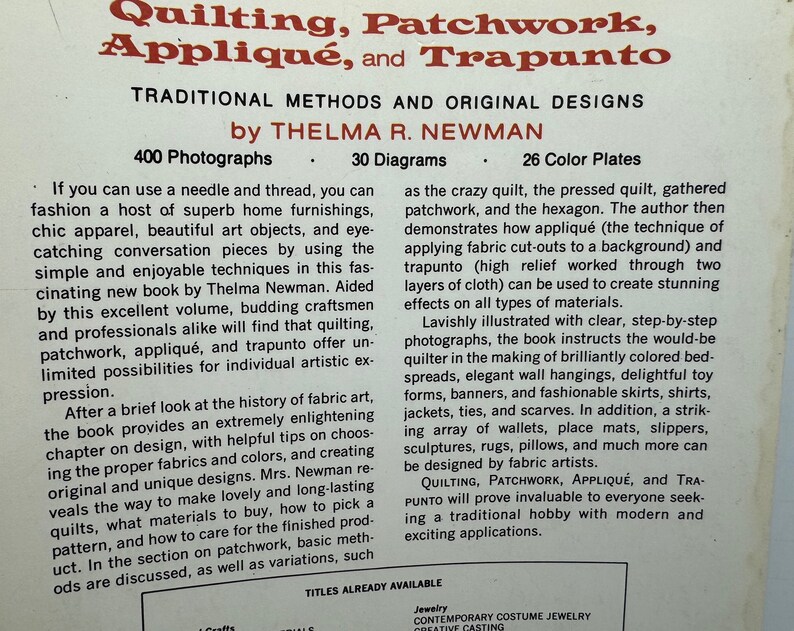 May include: Book cover with a title that reads "Quilting, Patchwork, Appliqu&eacute;, and Trapunto: Traditional Methods and Original Designs by Thelma R. Newman". The cover is white with red and black text. The book features 400 photographs and 30 diagrams.
