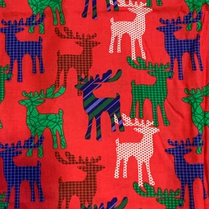 Puede incluir: Tela roja con un patrón repetido de renos en varios colores y patrones, incluyendo verde, azul, blanco y marrón.
