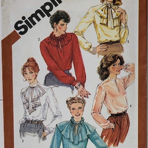 Puede incluir: Patrón de costura Simplicity número 5200 para una blusa con cuello de volantes y lazo. El patrón incluye cinco vistas diferentes de la blusa en varios colores, incluyendo rojo, blanco, amarillo, azul y rosa.