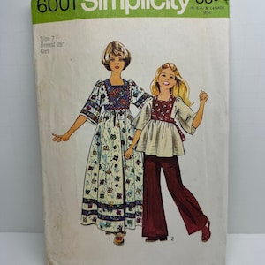 May include: Simplicity sewing pattern number 6001 for a girl's dress and pants. The pattern is for size 7, with a 26 inch bust. The dress is a long, flowing style with a floral print and a tie at the waist. The pants are a wide-leg style with a brown color.