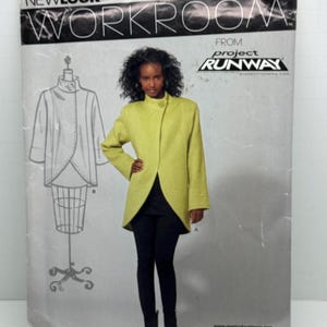 May include: A sewing pattern for a jacket with a high collar and a long, asymmetrical hemline. The pattern is from Project Runway and is for sizes 8-18. The pattern is on a white background with a black and white photo of a model wearing the jacket.