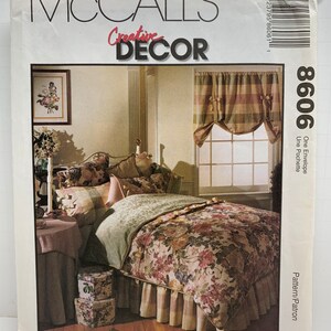 May include: A McCall's Creative Decor sewing pattern for a floral bed skirt and matching pillow covers. The pattern is for a bed skirt with a ruffled edge and a floral print. The pillow covers are also floral and have a ruffled edge. The pattern is for size 8606.