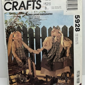 May include: A McCall's Crafts pattern envelope featuring two whimsical rabbit dolls. The rabbits are dressed in vintage-style clothing and seated on a wooden bench. The text on the envelope includes "Whimsical Wabbits" and "Never a Dull Needle."