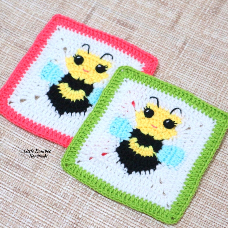 May include: Two crocheted squares featuring a bee design. The bee is yellow, black, and white with blue wings. One square has a pink border and the other has a green border. The text "Little Bamboo Handmade" is visible in the bottom left corner.