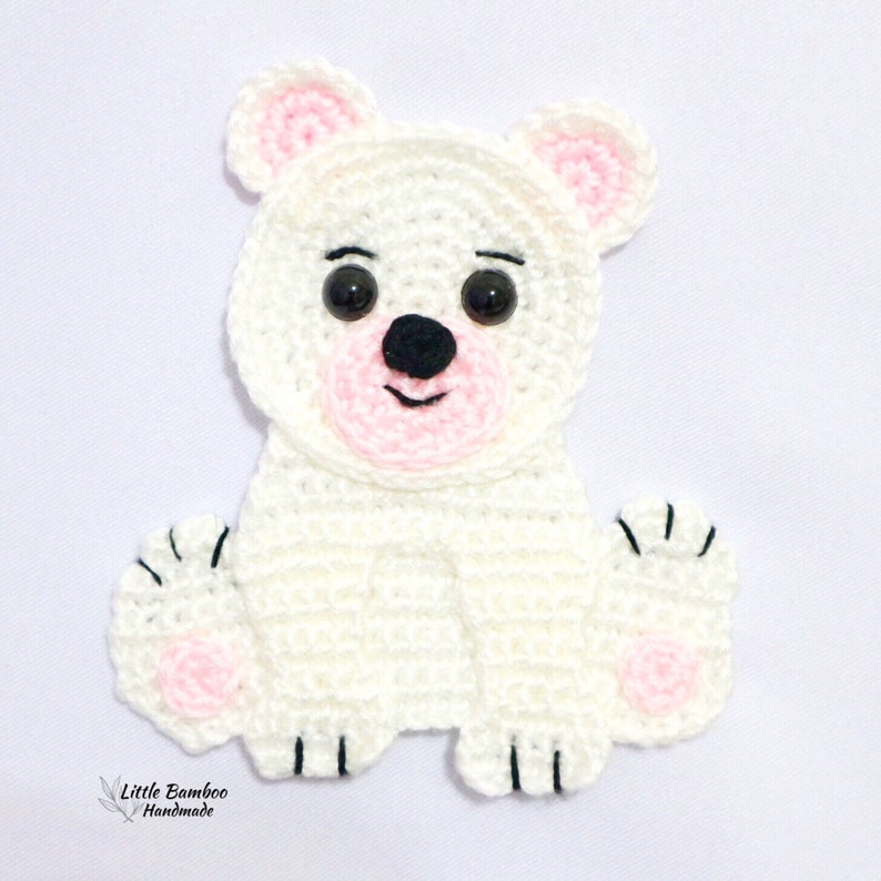May include: White crocheted polar bear applique with black eyes, black nose, and pink accents on the ears, mouth, and paws.