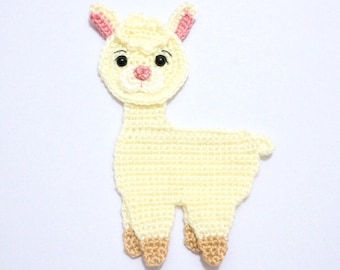 May include: A cream-colored crochet llama applique featuring a textured head with pink inner ears, a pink nose, and black bead eyes. The body has four legs with light brown hooves at the bottom. The text Little Bamboo Handmade is visible.