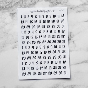 May include: A small white sticker sheet with black numbers from 1 to 31 arranged in rows. The text "jemdesigns" and "Q041" are printed at the top. The numbers are for calendar or planner use.