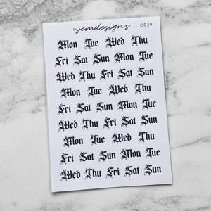 May include: A white sticker sheet featuring the days of the week in a gothic font. The days are arranged in rows and columns. The text "jemdesigns" and "0039" are printed at the top of the sheet.