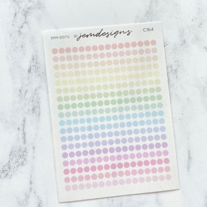 May include: A sheet of stickers featuring a grid of 3mm dots in pastel rainbow hues. The text "3MM DOTS by jemdesigns C164" is printed at the top. The stickers are on a white background.