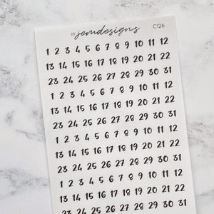 May include: A sheet of white sticker paper with black numbers 1 through 31 printed in a handwritten font. The numbers are repeated five times on the sheet. The text "jemdesigns" and "C126" are printed in the top right corner of the sheet.