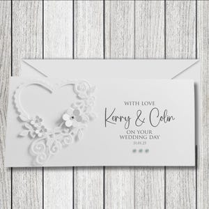 May include: White wedding card with a white lace heart design. The card says "With love Kerry & Colin On your wedding day 31.01.25"
