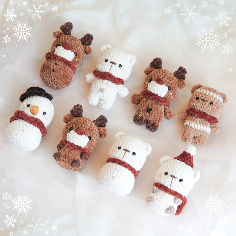 May include: Eight crocheted stuffed animals, including a snowman, reindeer, and polar bears, with brown and white fur and red scarves. The animals are arranged on a white background.