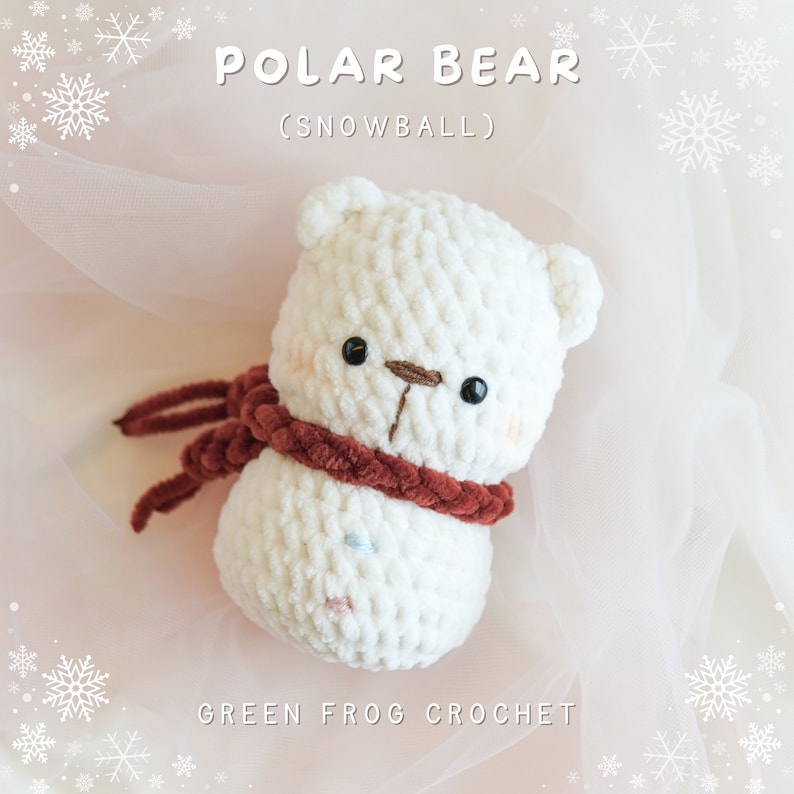 May include: A white crocheted polar bear wearing a red scarf, with the text "POLAR BEAR (SNOWBALL)" and "GREEN FROG CROCHET" on a pink background with white snowflakes.