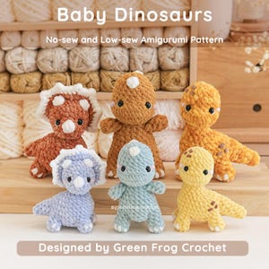 Puede incluir: Seis amigurumis de dinosaurios bebés tejidos a ganchillo en tonos marrón, naranja, azul y amarillo. El texto "Baby Dinosaurs" y "Designed by Green Frog Crochet" está presente.