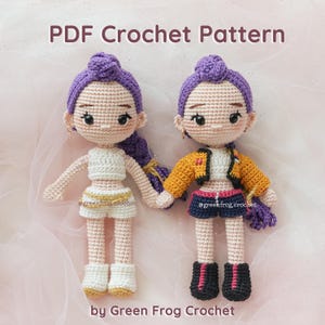 May include: Two handmade crochet dolls with purple hair, wearing different outfits. One doll is in a white crop top and shorts, the other in a yellow jacket and shorts. The text "PDF Crochet Pattern" and "by Green Frog Crochet" are visible.