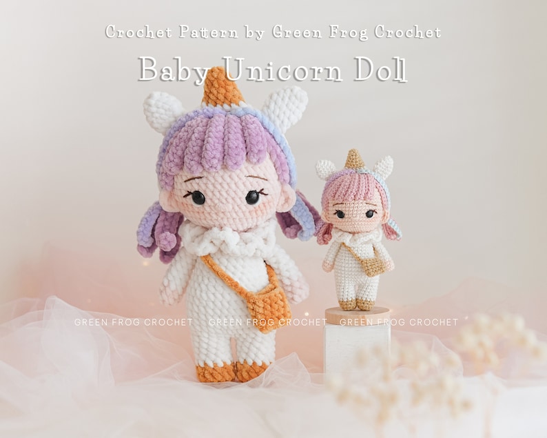 Puede incluir: Patr&oacute;n de crochet para una mu&ntilde;eca de unicornio beb&eacute;. La mu&ntilde;eca es rosa y blanca con una melena y cola moradas. La mu&ntilde;eca lleva una peque&ntilde;a bolsa blanca con una correa marr&oacute;n.