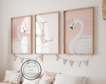 May include: Three framed prints with a pink background and white swans. The middle print features a pink letter L with floral accents and the name "Lily Rose" written below.