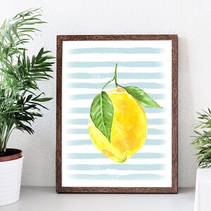 Puede incluir: Una pintura de acuarela de un lim&oacute;n amarillo con hojas verdes sobre un fondo de rayas azules y blancas.