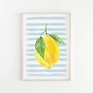 Puede incluir: Una pintura de acuarela de un lim&oacute;n amarillo con hojas verdes colgando de una rama sobre un fondo de rayas azules y blancas.