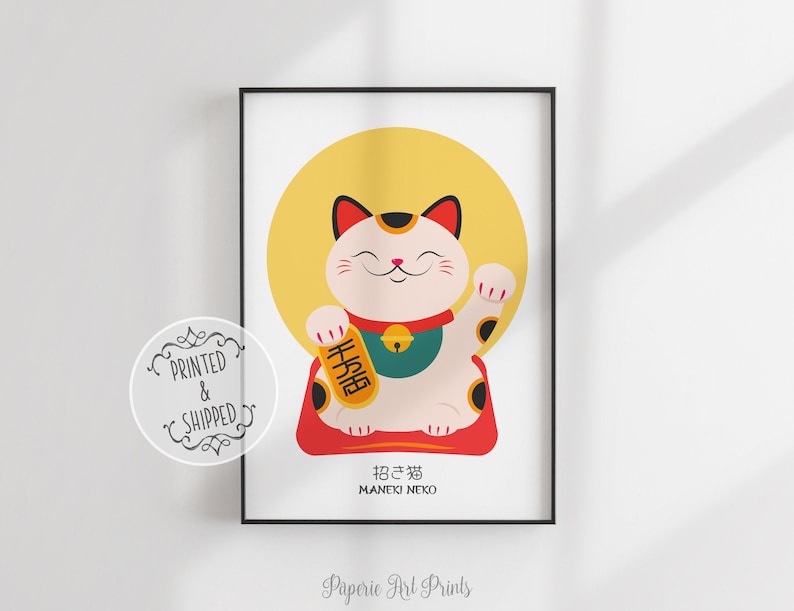 May include: A white Maneki-Neko, or lucky cat, with black spots, is sitting on a red cushion. The cat is holding a gold coin in its right paw and has a yellow halo behind it. The text "招き猫" (Maneki-Neko) is written in Japanese below the cat.