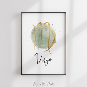 May include: A watercolor print of the Virgo zodiac sign in gold with a green background. The word "Virgo" is written in black cursive below the sign.