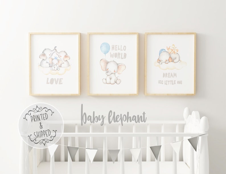 May include: Three framed prints with watercolor illustrations of elephants. The first print features a family of elephants with the word "LOVE" below. The second print features an elephant with a blue balloon and the words "HELLO WORLD". The third print features two elephants sleeping on a cloud with the words "DREAM BIG LITTLE ONE".