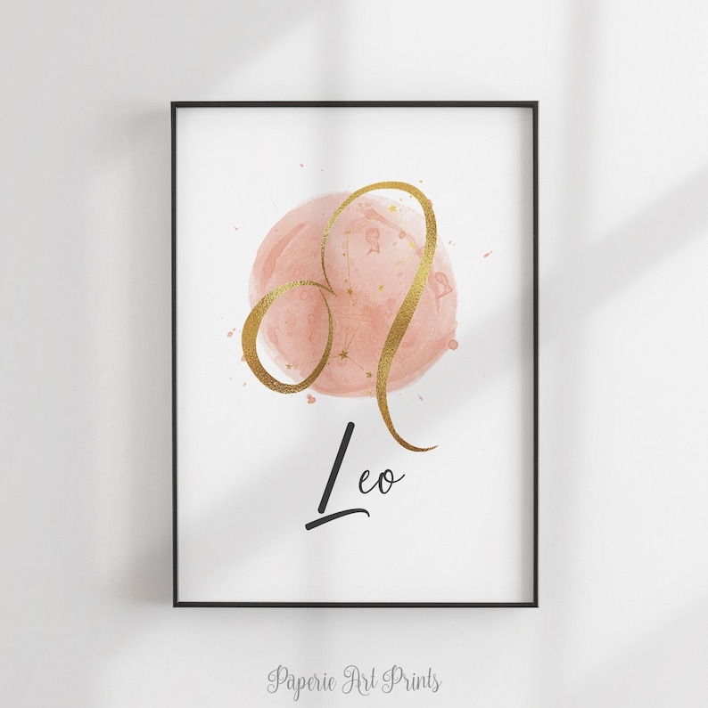 May include: A pink watercolor circle with gold glitter and a gold outline of the Leo constellation. The word "Leo" is written in black cursive below the circle.