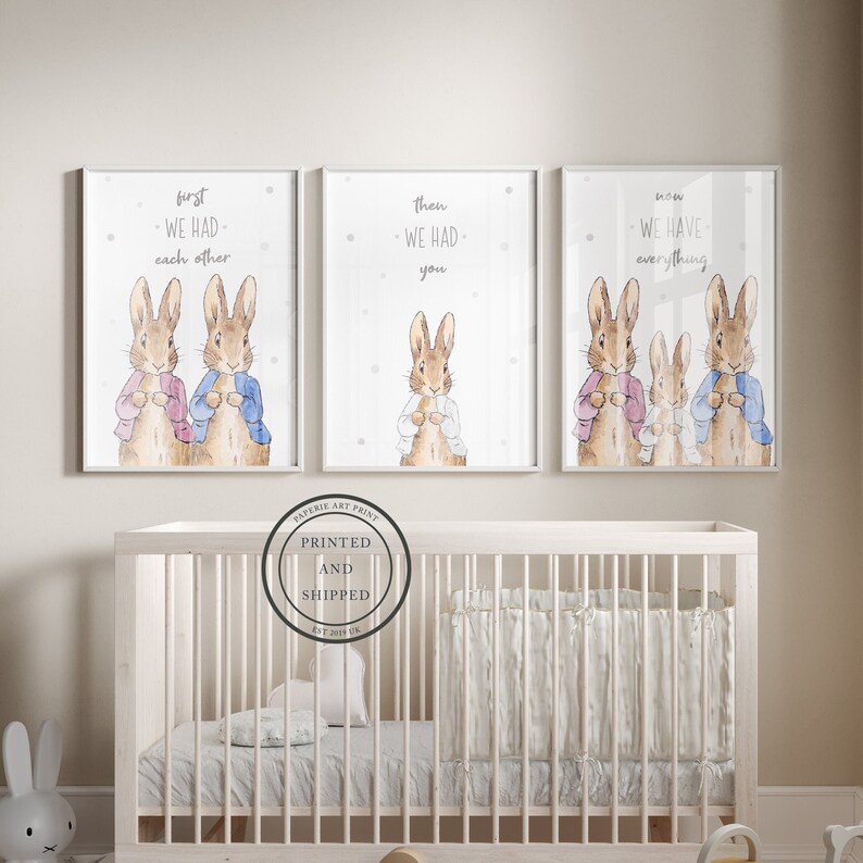 K&ouml;nnte beinhalten: Drei Aquarell-Drucke mit Peter Rabbit und seiner Familie. Die Drucke sind in Wei&szlig; gerahmt und haben einen wei&szlig;en Hintergrund mit grauen Punkten. Der erste Druck sagt "first we had each other". Der zweite Druck sagt "then we had you". Der dritte Druck sagt "now we have everything".