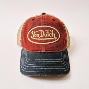 Puede incluir: Una taza de cer&aacute;mica blanca con asa negra y el texto "But First, Coffee" en negrita negra. La taza se encuentra sobre un fondo borroso, sugiriendo un ambiente acogedor.