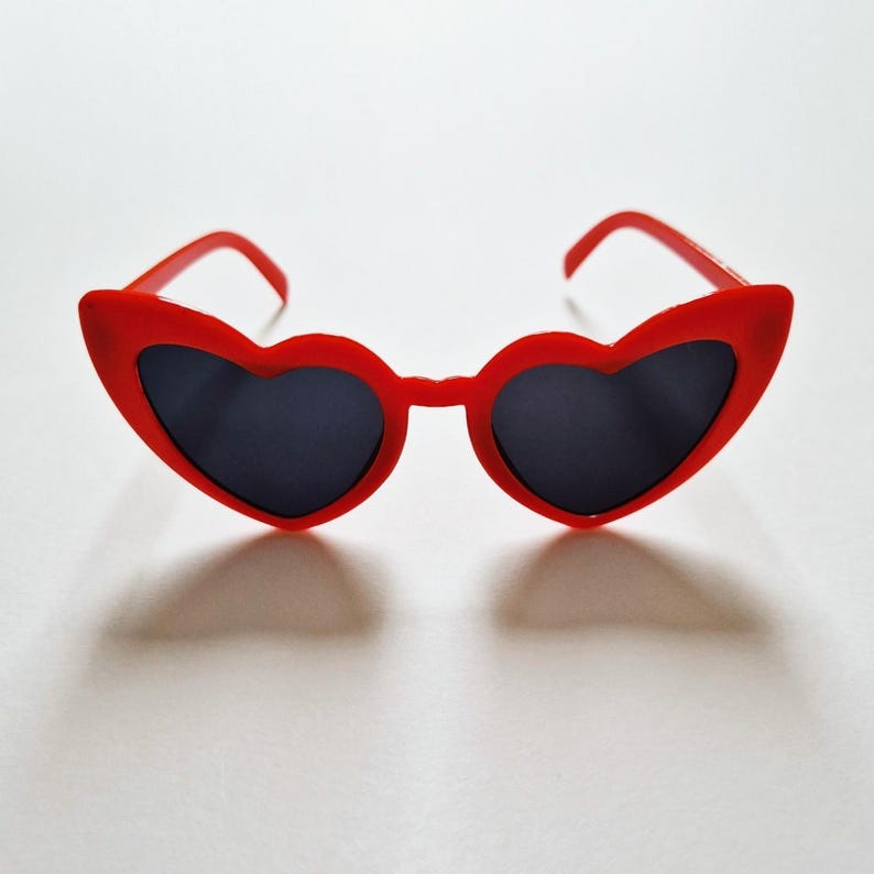 May include: Red heart-shaped sunglasses with black lenses.