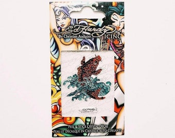 May include: A red and orange fish with blue and green crystal embellishments on a white background. The packaging features the text "Ed Hardy By Christian Audigier ICING" and "PEEL & STICK CRYSTAL DECAL PEAU ET DÉCALQUE EN CRISTAUX AUTO-COLLANTS".