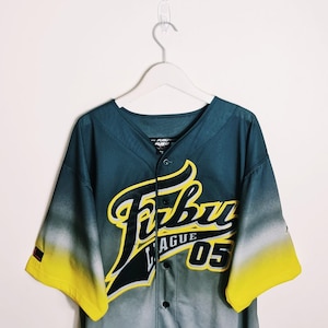 Può includere: Una maglia da baseball nera e gialla con un effetto sfumato. La maglia ha una grande grafica "Fubu League 05" sul davanti.