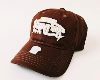 May include: A brown baseball cap with a white embroidered logo that says "Yon Drip".