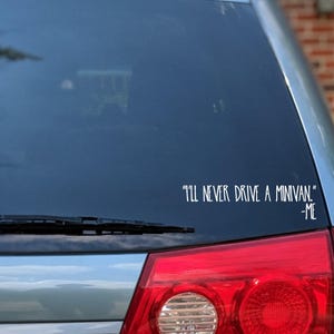 May include: A car window decal with the text "I'll never drive a minivan" in white, with "-Me" below. The decal is on the rear window of a silver car, with the taillight visible.