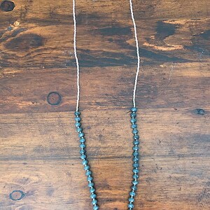 White, gold, and gray beaded necklace with triangle druzy pendant