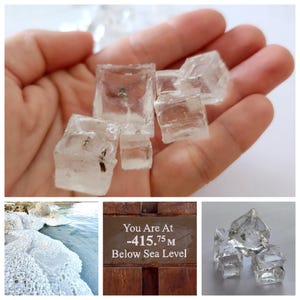 May include: Clear, crystalline salt cubes with visible mineral inclusions. The image includes a view of a salt-crusted shoreline, a brown sign reading "You Are At -415.75 M Below Sea Level," and a collection of these translucent, geometric salt crystals.