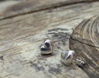 May include: A pair of silver heart-shaped earrings with a textured finish.