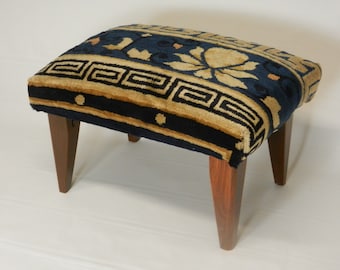 May include: A small, blue and tan patterned footstool with four wooden legs.