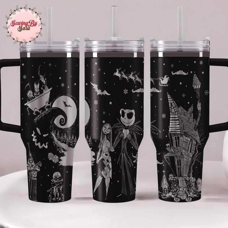 A set of three black tumblers with Halloween-themed designs printed on them.