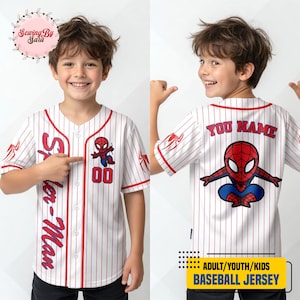 A young boy wearing a Spider-Man baseball jersey with the name "Sara" and the number "00" printed on it. The boy is smiling and pointing at the jersey.