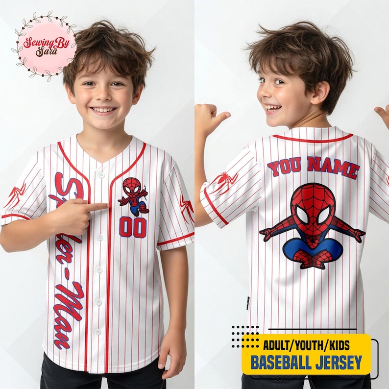 A young boy wearing a Spider-Man baseball jersey with the name "Sara" and the number "00" printed on it. The boy is smiling and pointing at the jersey.