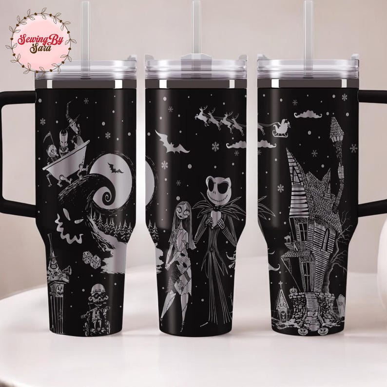 A set of three black tumblers with Halloween-themed designs printed on them.