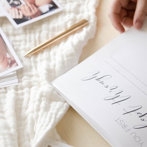 May include: A white journal with the text 'You first slept for the night' and 'Sleepy Baby' written in black cursive script.