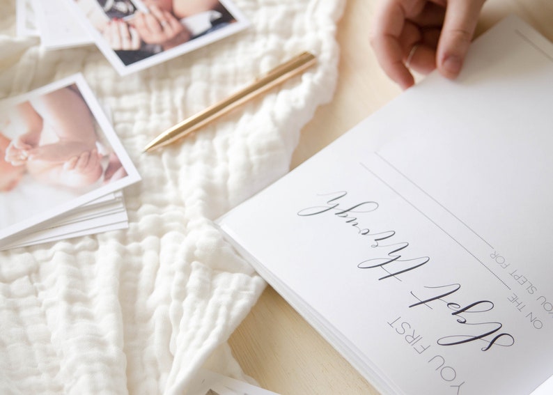 May include: A white journal with the text 'You first slept for the night' and 'Sleepy Baby' written in black cursive script.