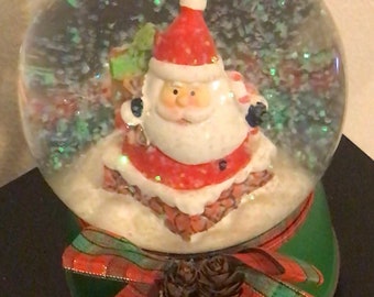 Christmas snow globe, musical Gnome water globe base has a ribbon pine cones, and a glittered snowfall! Great Christmas gift!